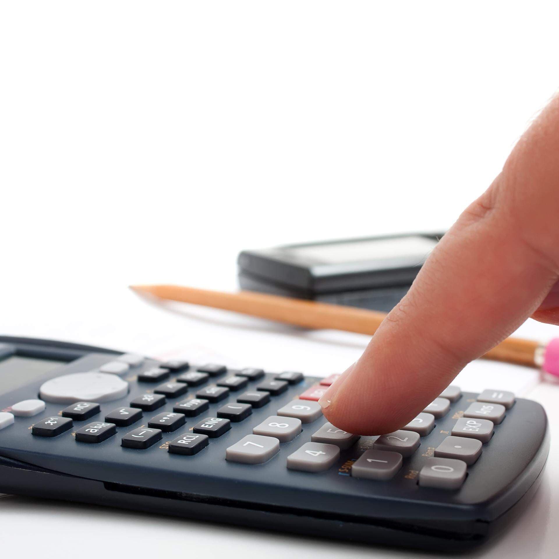 Finger som slår på en miniräknare
