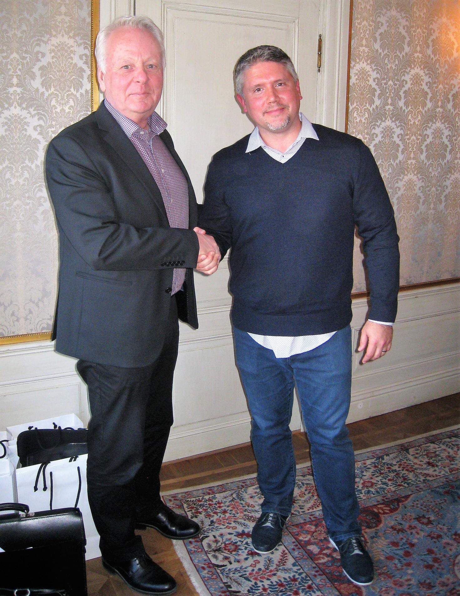 Göran Dahlström, kommunstyrelsens ordförande skakar hand med Darren Mowry från Amazon.