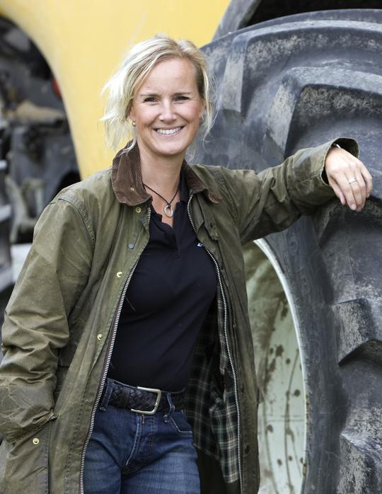 Annika Bergman brevid en traktor på sin gård