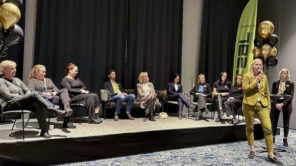 Paneldeltagare sitter på en scen